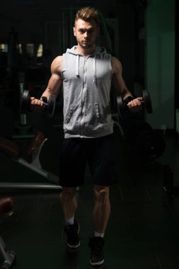 Genç adam için pazı Dumbbells ile egzersiz yaparak