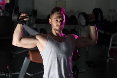 Omuz egzersiz Dumbbells ile genç adam