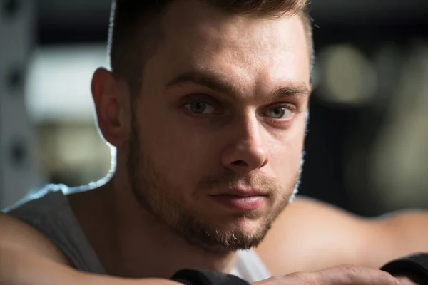 Attraktiver junger Mann ruht sich nach dem Sport im Fitnessstudio aus — Stockfoto