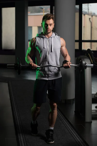 Kulturista cvičení Biceps s činka v tělocvičně — Stock fotografie