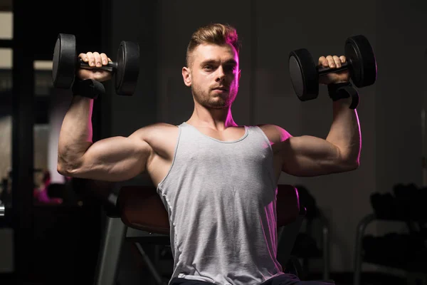 Exercice des épaules avec haltères dans une salle de gym — Photo