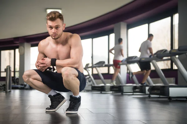 Привлекательный молодой человек отдыхает в спортзале после тренировки — стоковое фото