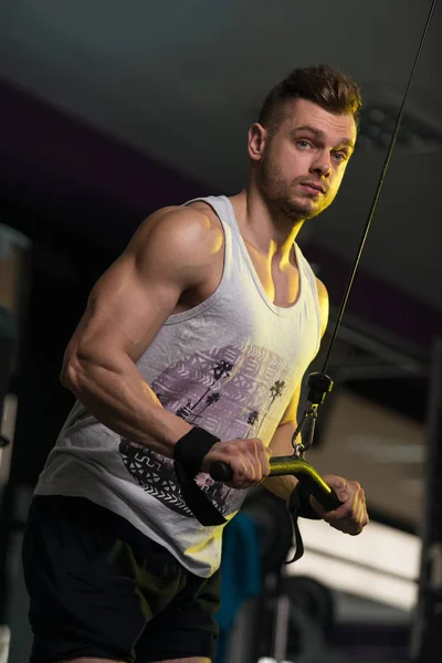 Mladý muž cvičit triceps v tělocvičně — Stock fotografie