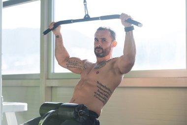 Kaslı adam arka için ağır egzersiz yaparak