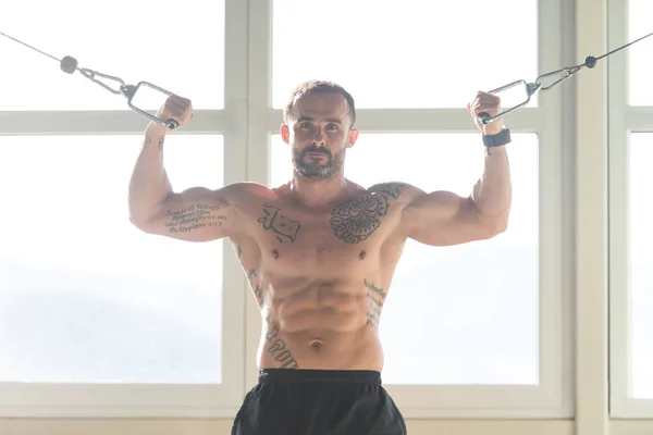 Svalnatý muž cvičení Biceps na kabel stroj — Stock fotografie