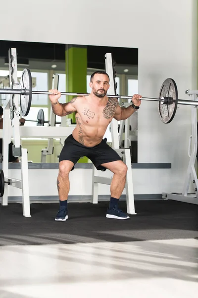 Homem de fitness usando Barbell Exercício Pernas dentro do ginásio — Fotografia de Stock