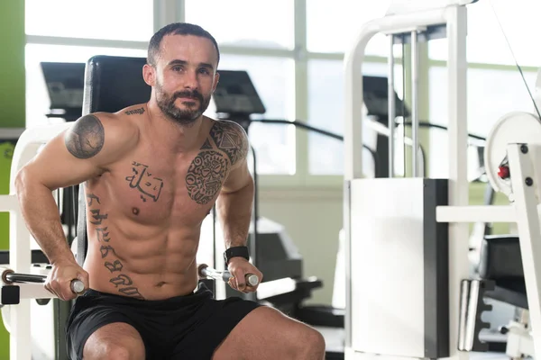 Muskulöser Mann trainiert Trizeps an Maschine — Stockfoto
