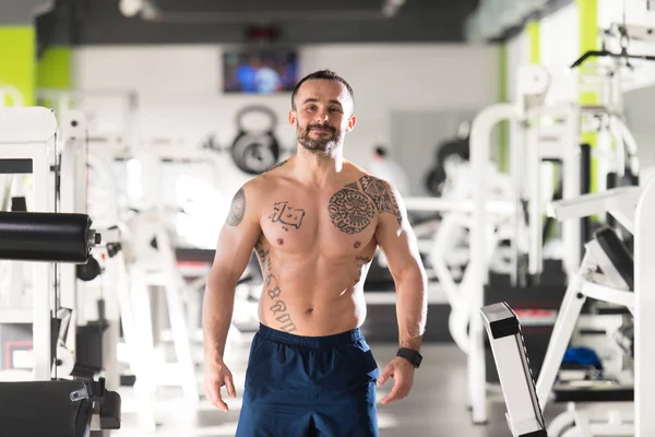 Bonito Muscular Homem Flexante Músculos Em Ginásio — Fotografia de Stock