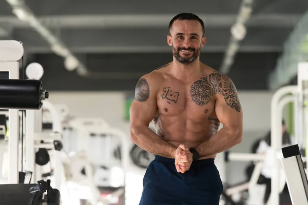 Bonito Muscular Homem Flexante Músculos Em Ginásio — Fotografia de Stock