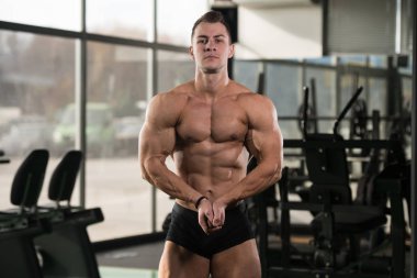 Yakışıklı kaslı adam içinde jimnastik salonu kas esneme