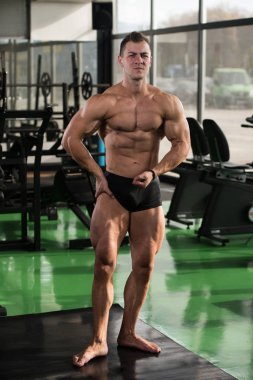 Yakışıklı kaslı adam içinde jimnastik salonu kas esneme