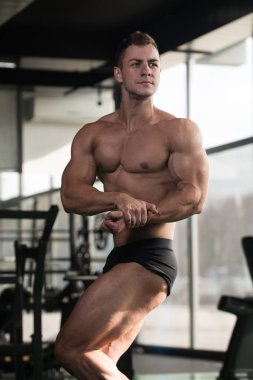 Yakışıklı kaslı adam içinde jimnastik salonu kas esneme