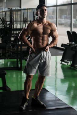 Yakışıklı kaslı adam içinde jimnastik salonu kas esneme