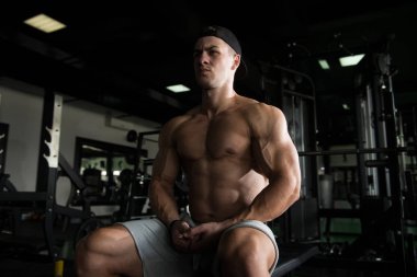 adam bir egzersiz yaptıktan sonra spor salonunda aittir.