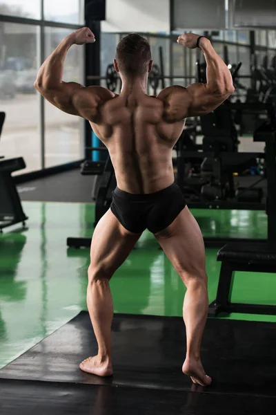 Muscular Man Flexing Back Muscles Pose — Stock Photo, Image