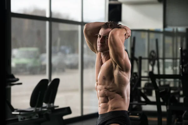 Человек в спортзале показывает свое хорошо подготовленное тело — стоковое фото
