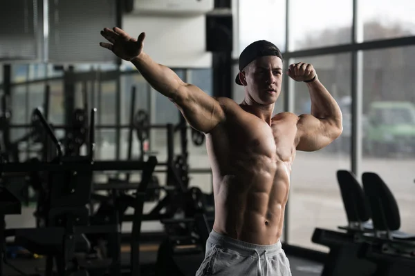 Muskularny mężczyzna wyginanie mięśni w siłowni — Zdjęcie stockowe