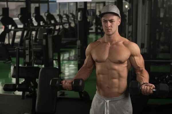 Jeune homme avec haltère exercice Biceps — Photo