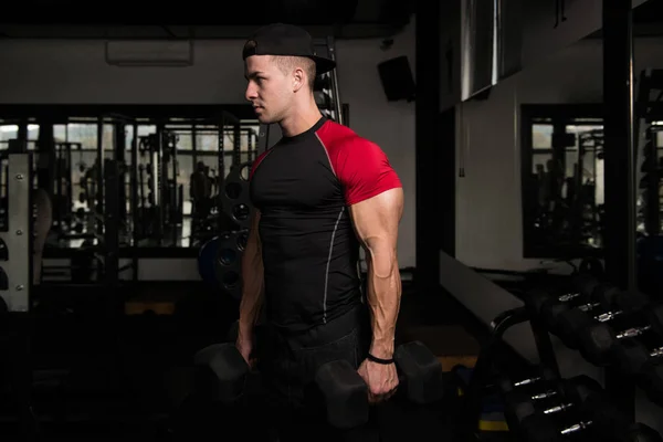 Muskulöser Mann trainiert Bizeps mit Kurzhantel — Stockfoto