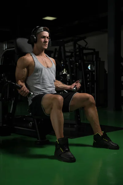 Atleta trabalhando fora bíceps em um ginásio — Fotografia de Stock