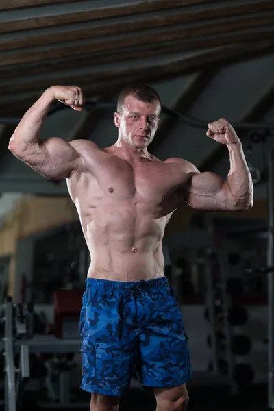 Hombre en el gimnasio mostrando su cuerpo bien entrenado — Foto de Stock