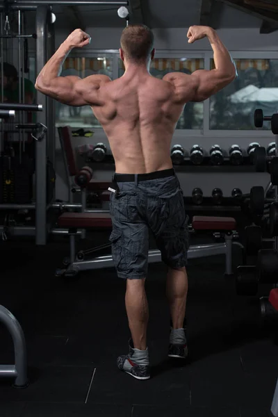 Muscular Man Flexing Back Muscles Pose — Stock Photo, Image