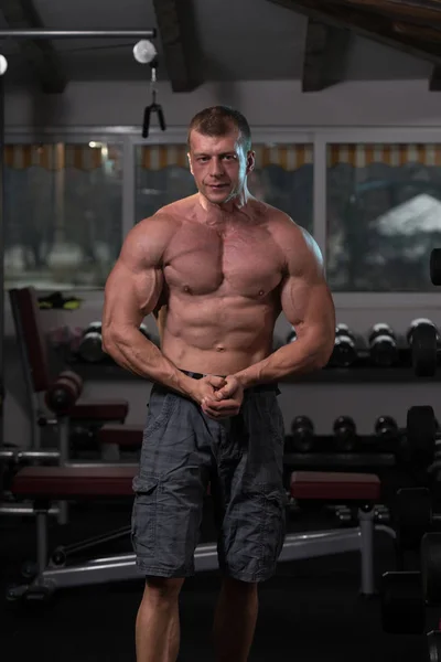 ジムで筋肉を曲げる筋肉の男 — ストック写真