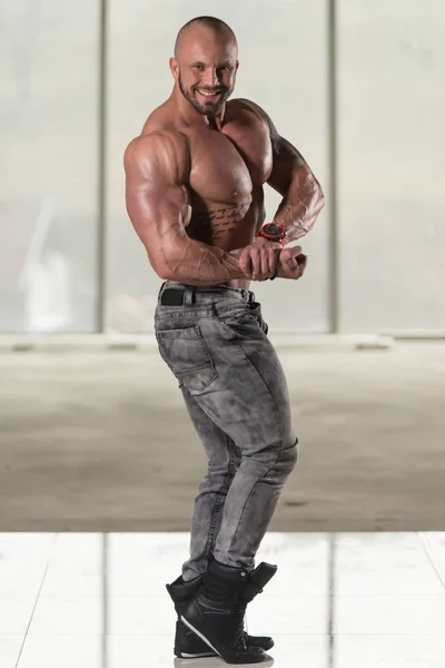 Hombre musculoso guapo flexionando músculos en el gimnasio —  Fotos de Stock