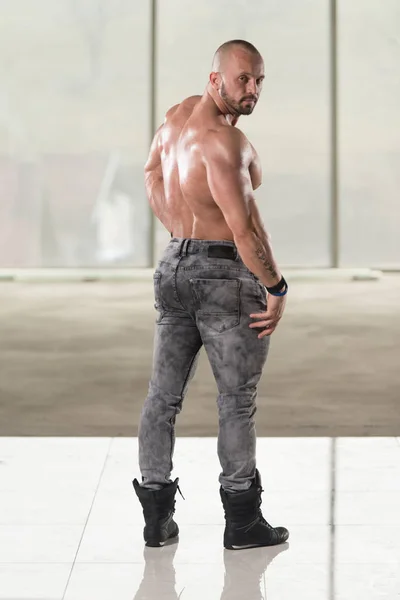 Muskulös Man flexar ryggmusklerna Pose — Stockfoto