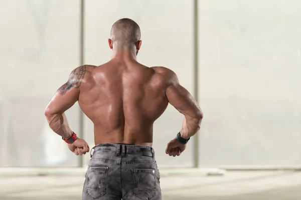 肌肉男弯曲背部肌肉的姿势 — 图库照片