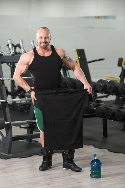 Bodybuilder posiert mit T-Shirt für Kopierraum — Stockfoto