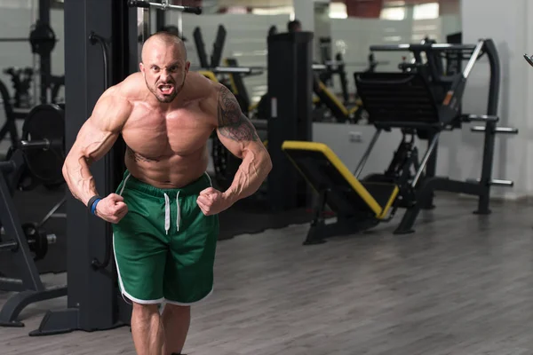 Homem mostrando seu corpo bem treinado no ginásio — Fotografia de Stock
