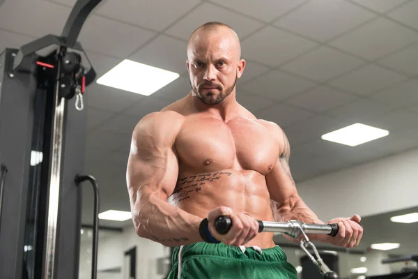 Człowiek robi ćwiczenia na Biceps na kabel maszyny — Zdjęcie stockowe