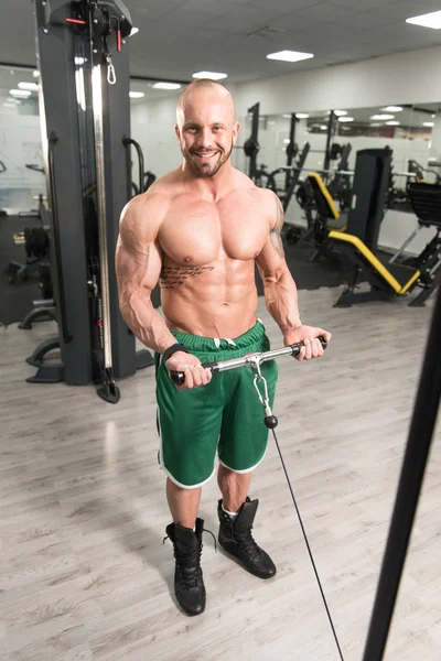 Krachtig gespierde Man uitoefening Biceps op kabel Machine — Stockfoto