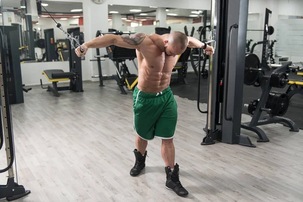 Man gör övning för Biceps på kabel maskin — Stockfoto