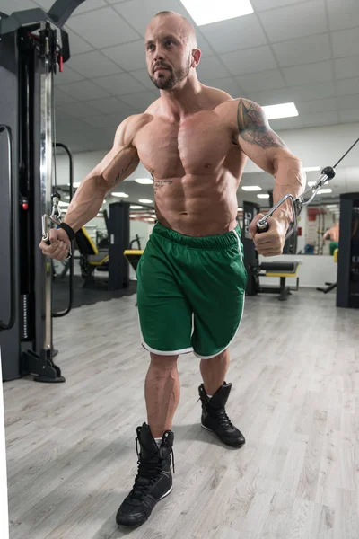 Hombre haciendo ejercicio para bíceps en la máquina de cable — Foto de Stock