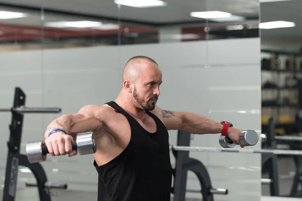 Esercizio della spalla con manubri in una palestra — Foto Stock