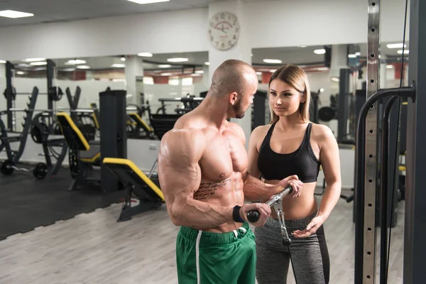 Man uitoefening Biceps met haar Personal Trainer — Stockfoto