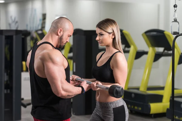 Vrouw uitoefening Biceps met haar Personal Trainer — Stockfoto