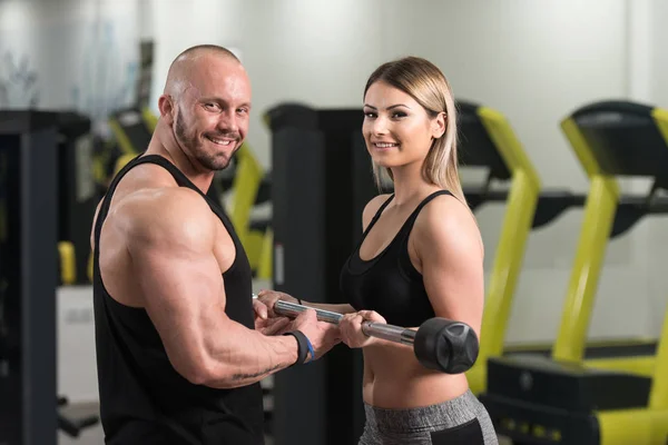 Donna che esercita Bicipiti con il suo personal trainer — Foto Stock