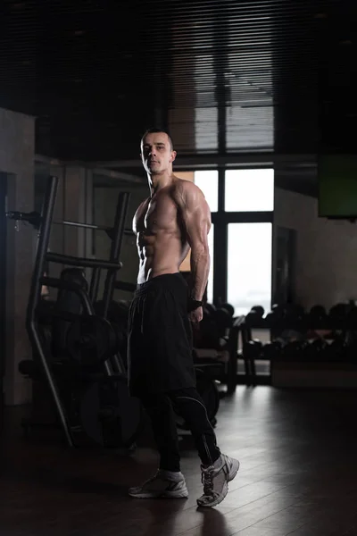 Homme dans la salle de gym montrant son corps bien formé — Photo