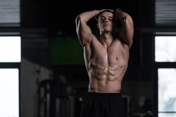 Hombre en el gimnasio mostrando su cuerpo bien entrenado — Foto de Stock