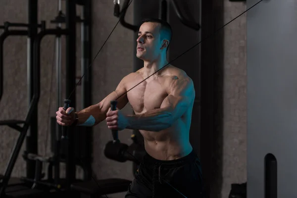 Hombre haciendo ejercicio para bíceps en la máquina de cable — Foto de Stock