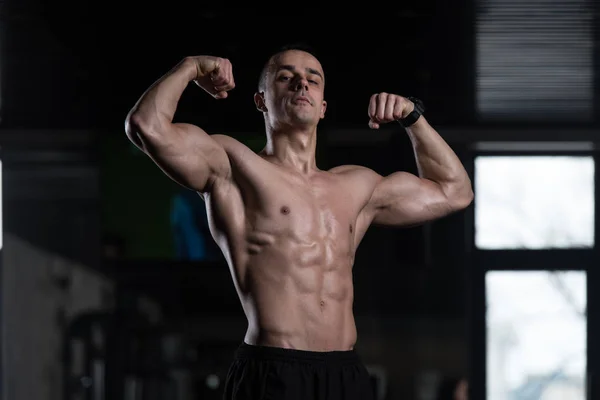 Jonge bodybuilder buigen spieren — Stockfoto