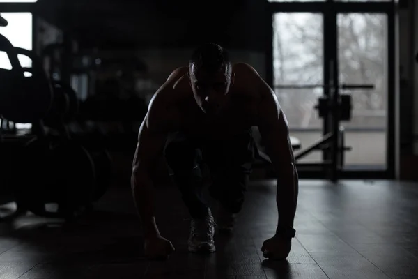 Siluet fuerte musculoso hombre arrodillado en el suelo —  Fotos de Stock