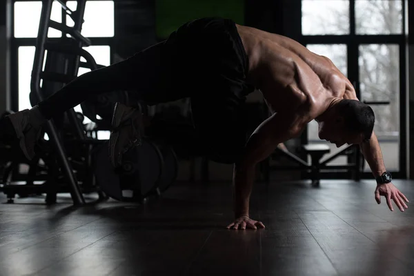 Atleta haciendo extremo handstand en gimnasio — Foto de Stock