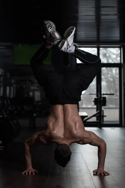 Спортсмен делает экстремальные подталкивания на стойке на полу — стоковое фото
