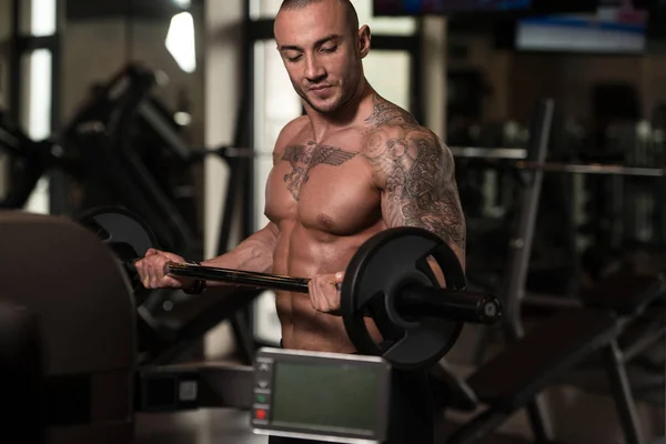 Bodybuilder exécution biceps boucles avec un haltère — Photo