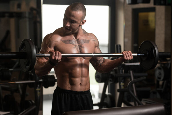 Bodybuilder Performing Biceps Curls With A Barbell