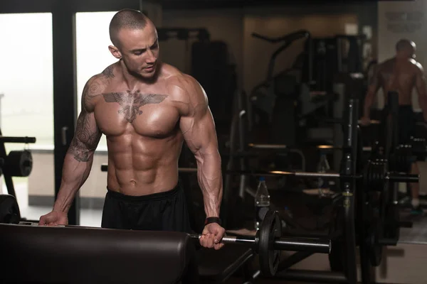 Bodybuilder uitoefening Biceps met Barbell In sportschool — Stockfoto